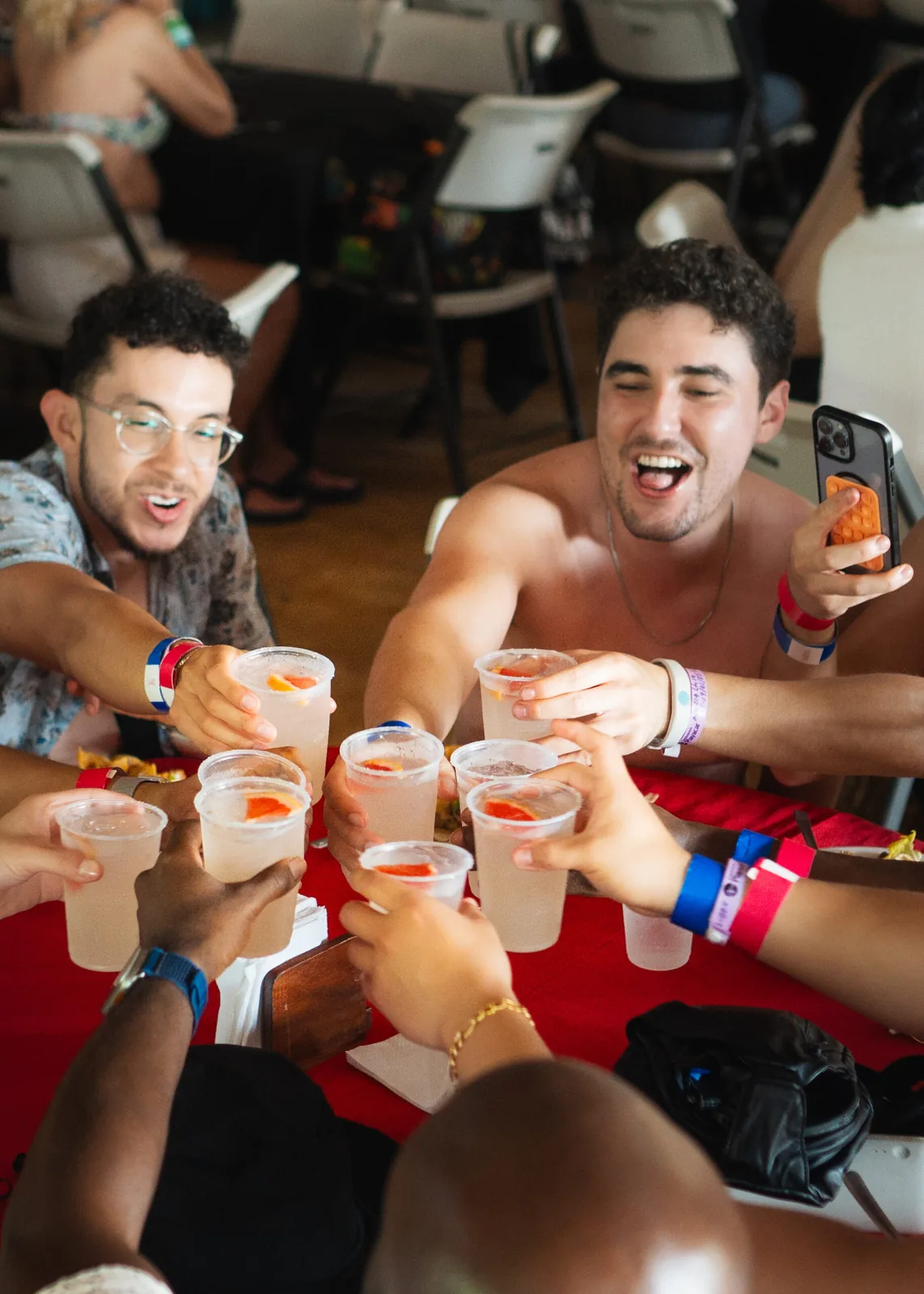 A group of friends raising their drinks in a lively toast, smiling and enjoying the moment.