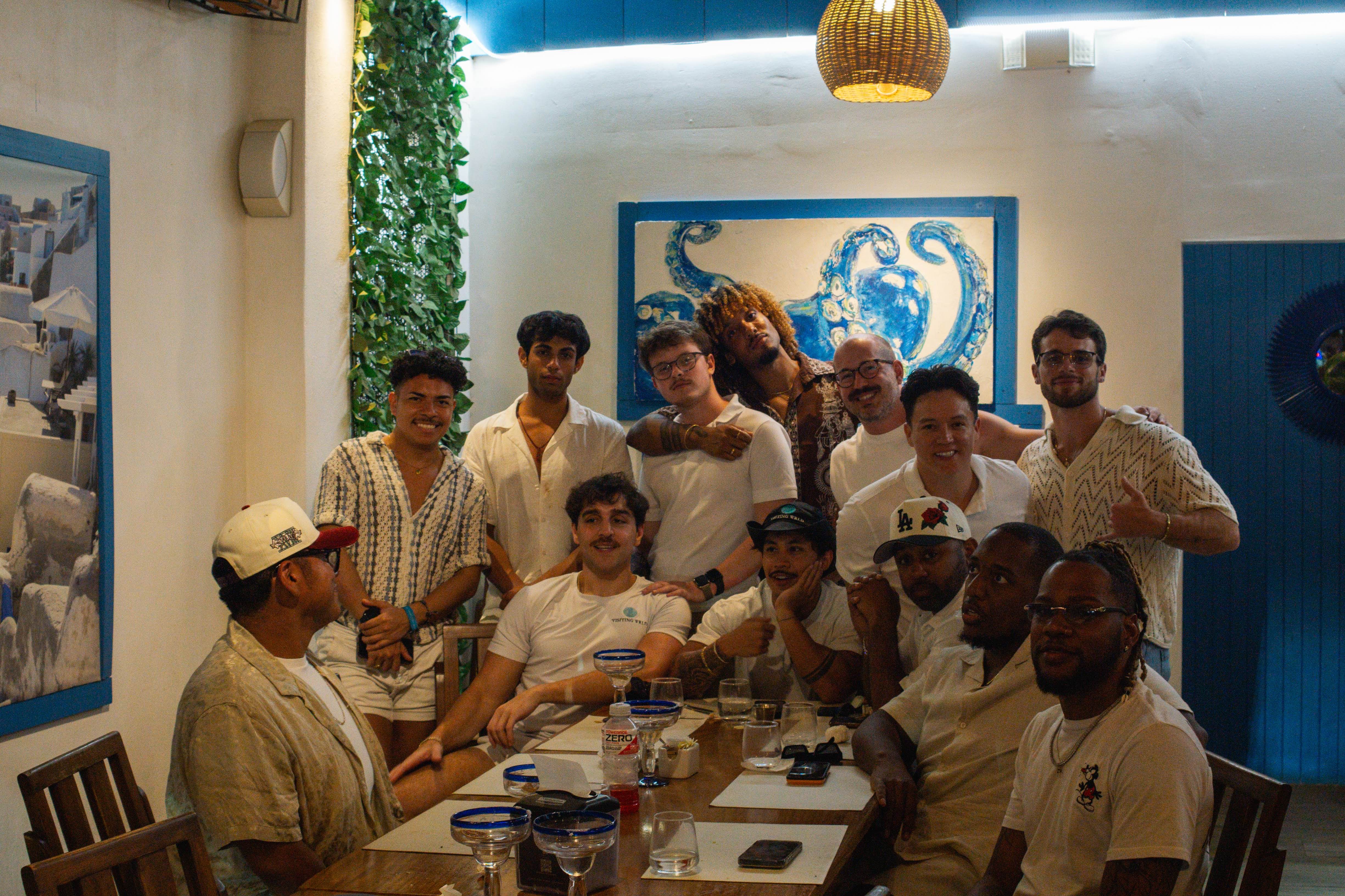 Group of men huddled together at a dinner table