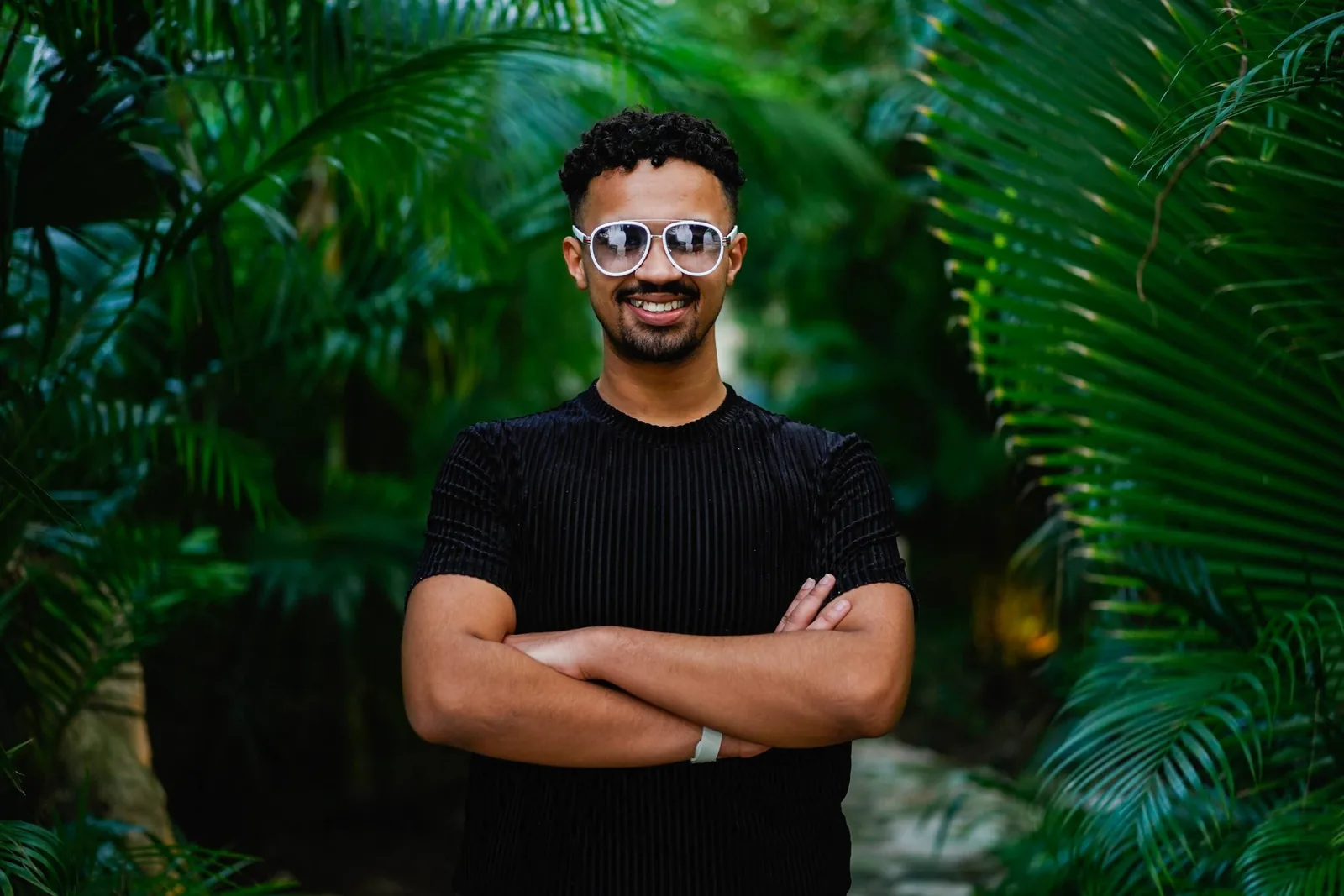 LGBTQ+ retreat participant posing confidently in a lush tropical setting