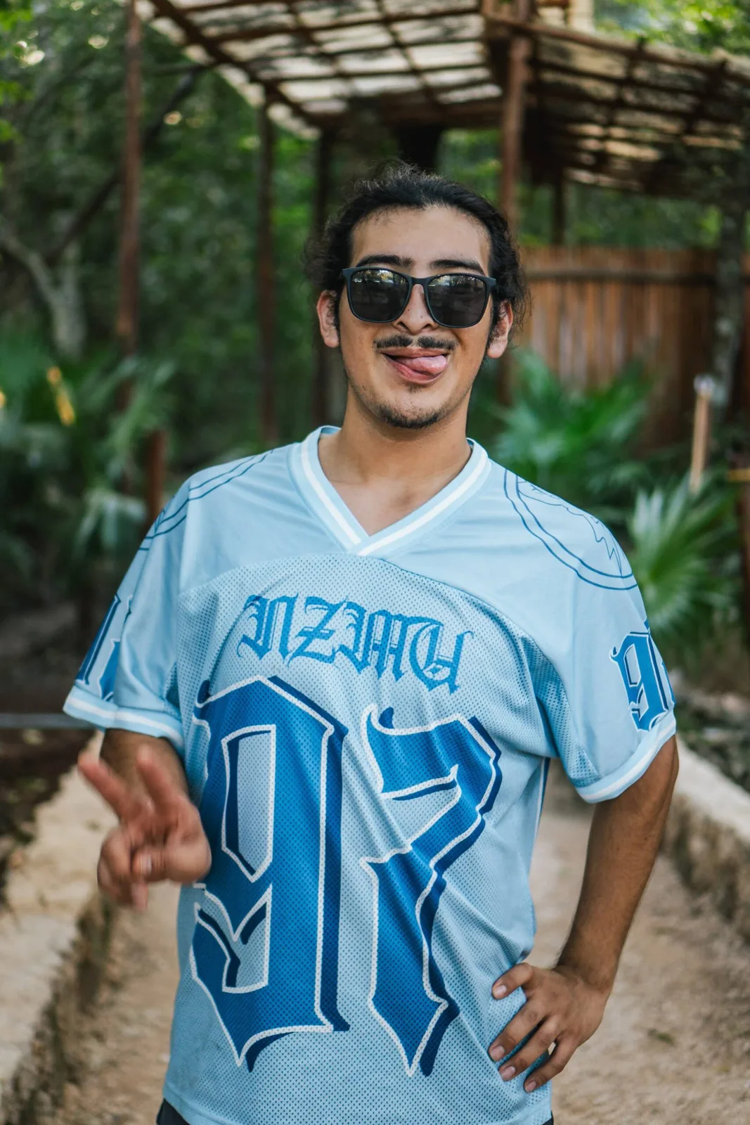Retreat participant wearing a blue jersey, posing playfully at the Visiting Wrld LGBTQ+ Fitness Retreat