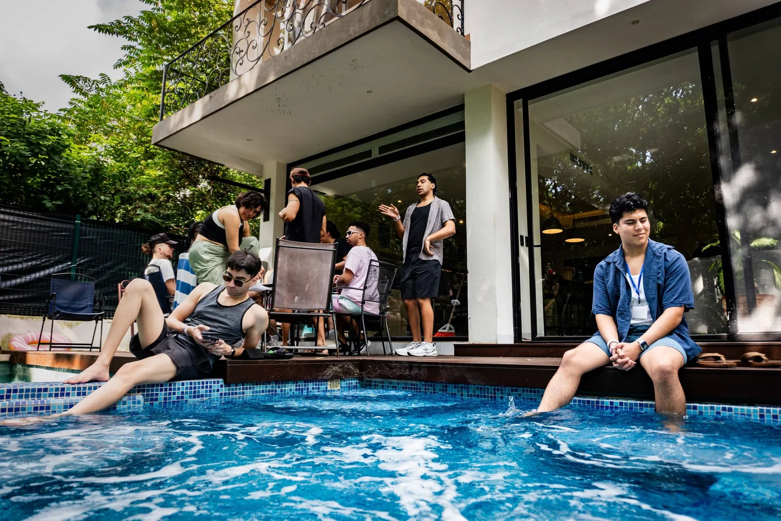 Retreat participants relaxing by the pool, socializing, and enjoying the tropical atmosphere